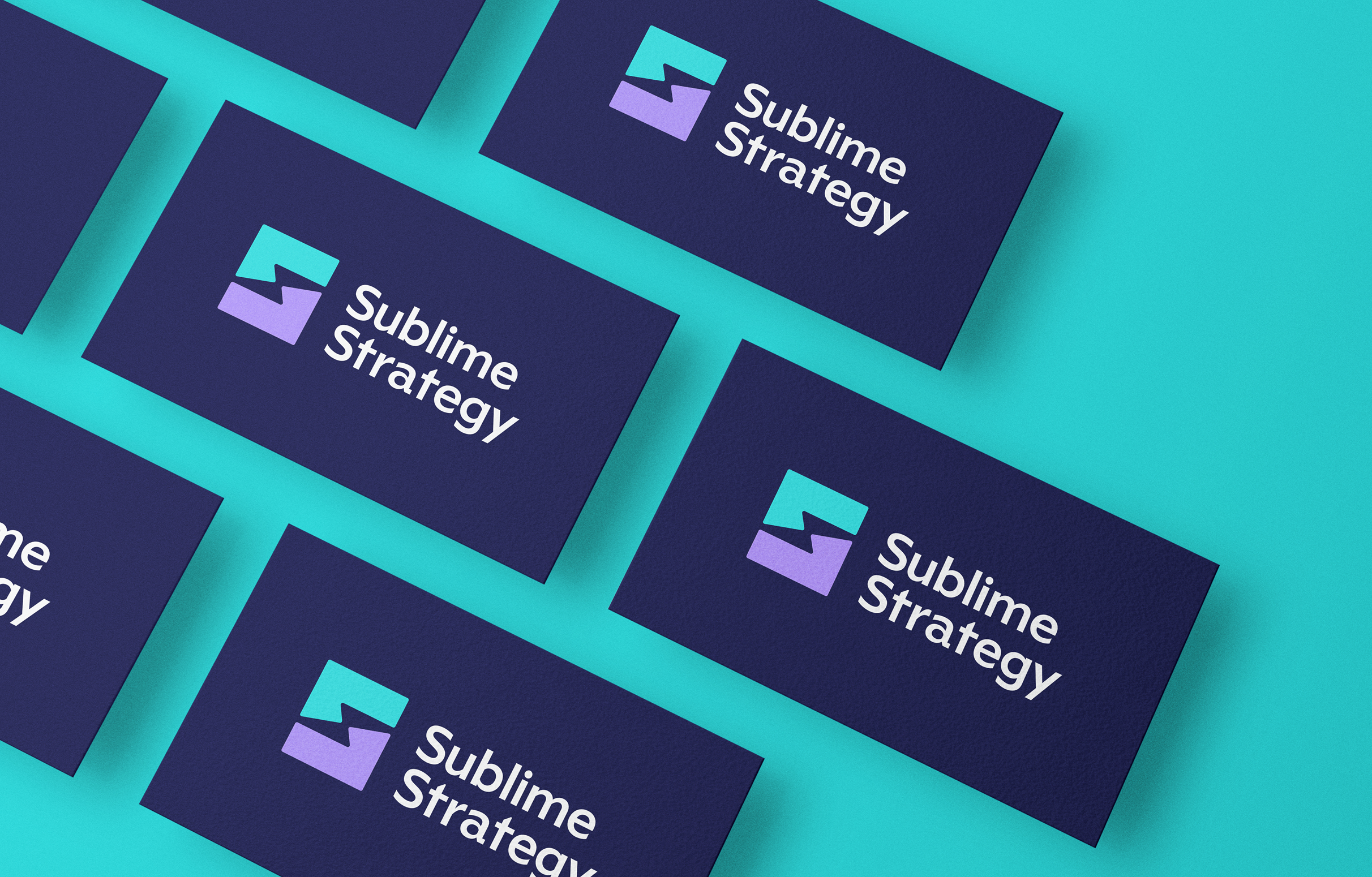 Multiple blue business cards, each with the Sublime Strategy logo, sit on a teal background. The logo is made up of a teal and purple icon forming a lightning bolt in the negative space with the text "Sublime Strategy" in white.
