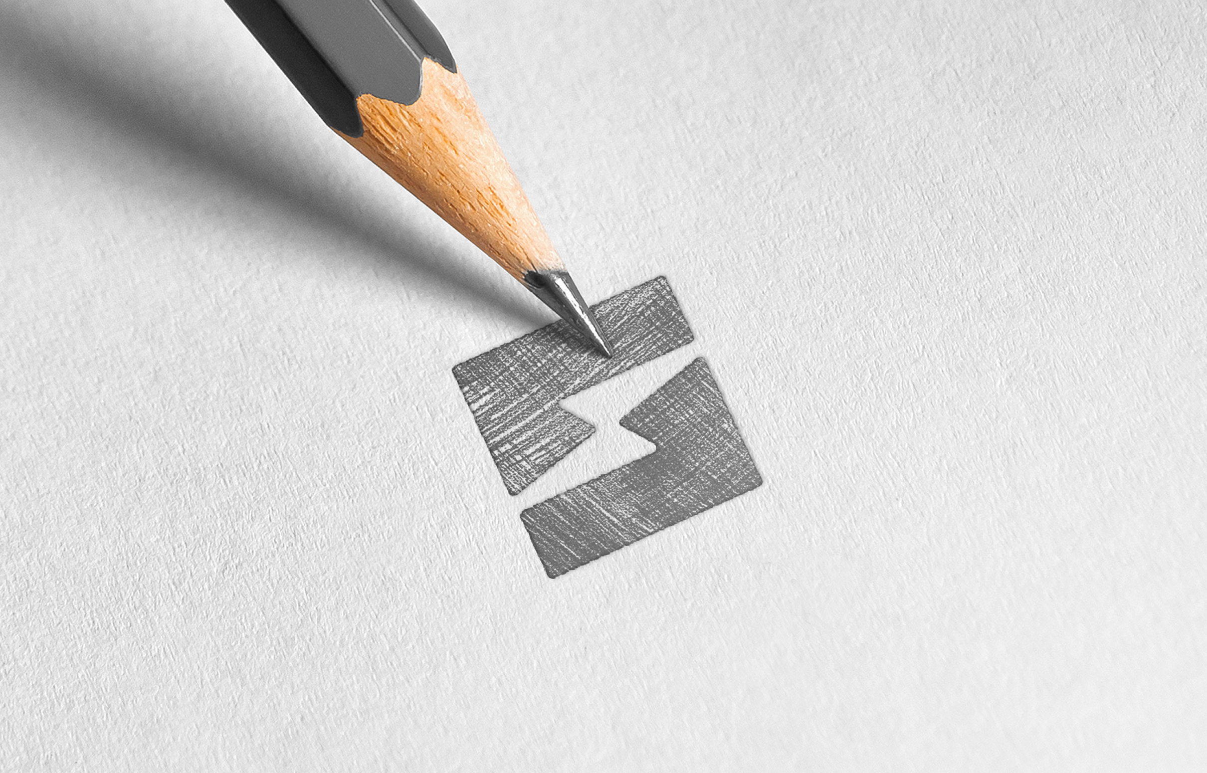 A sharp pencil sketches a geometric logo on white paper. The logo features two rectangles with a lightning bolt in between, conveying precision and creativity.