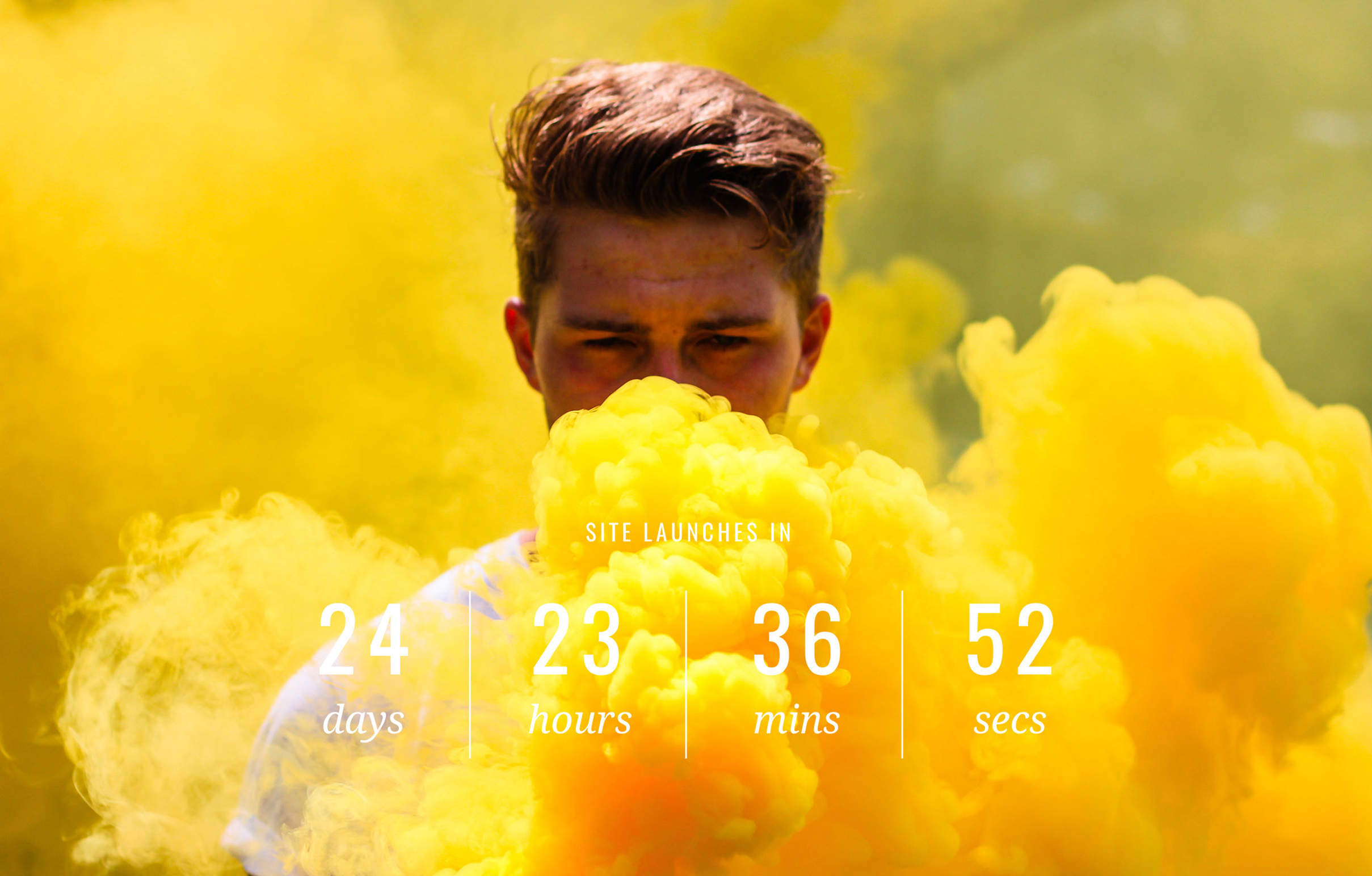Work-Merk-SiteLaunch A person stands amidst vibrant yellow smoke outdoors. Overlay text reads "Site launches in 24 days, 23 hours, 36 mins, 52 secs."