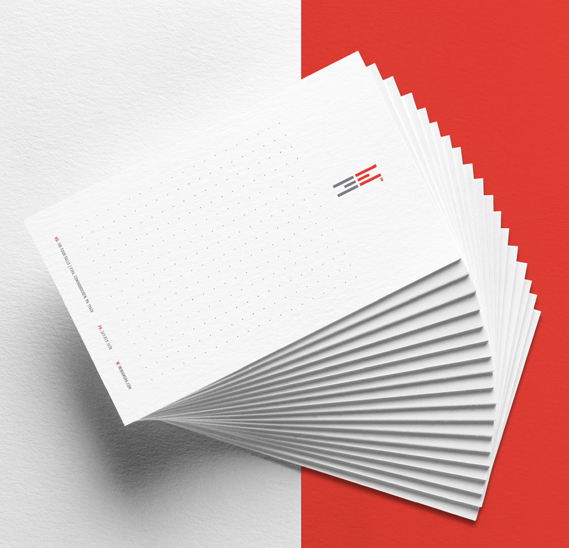 Work-Merk-Stationery A stack of white notepads with subtle dotted grids lies against a split background of white and vibrant red. Minimalist design evokes a modern, professional feel.