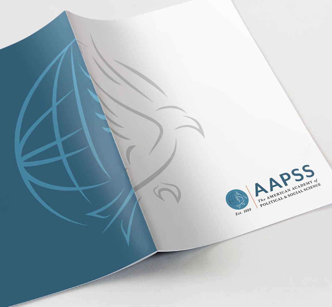 Blue and white brochure cover with globe and eagle designs. The AAPSS logo and "Est. 1889" are visible, conveying professionalism and academic focus.