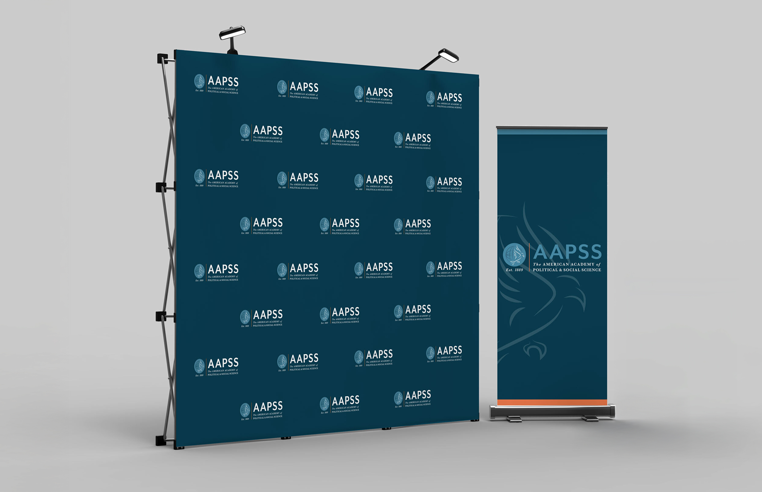 Banner setup with blue background featuring AAPSS logo and text. Two lights on top frame a professional, academic, and formal presentation setting.