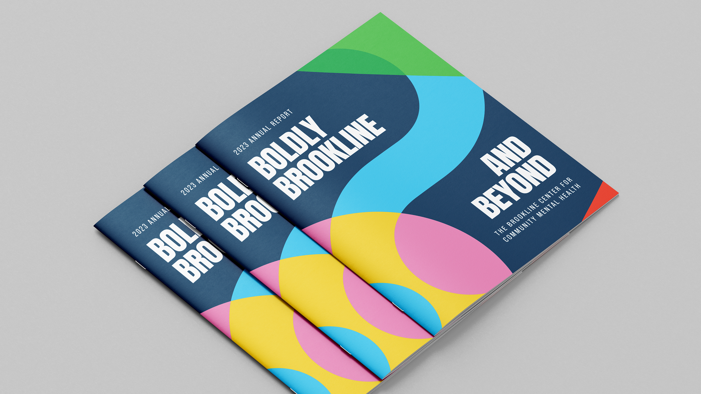 Brookline-Hero Cover of the 2023 Brookline annual report titled "Boldly Brookline and Beyond" in bold, white text on a dark blue background. Features colorful geometric patterns.