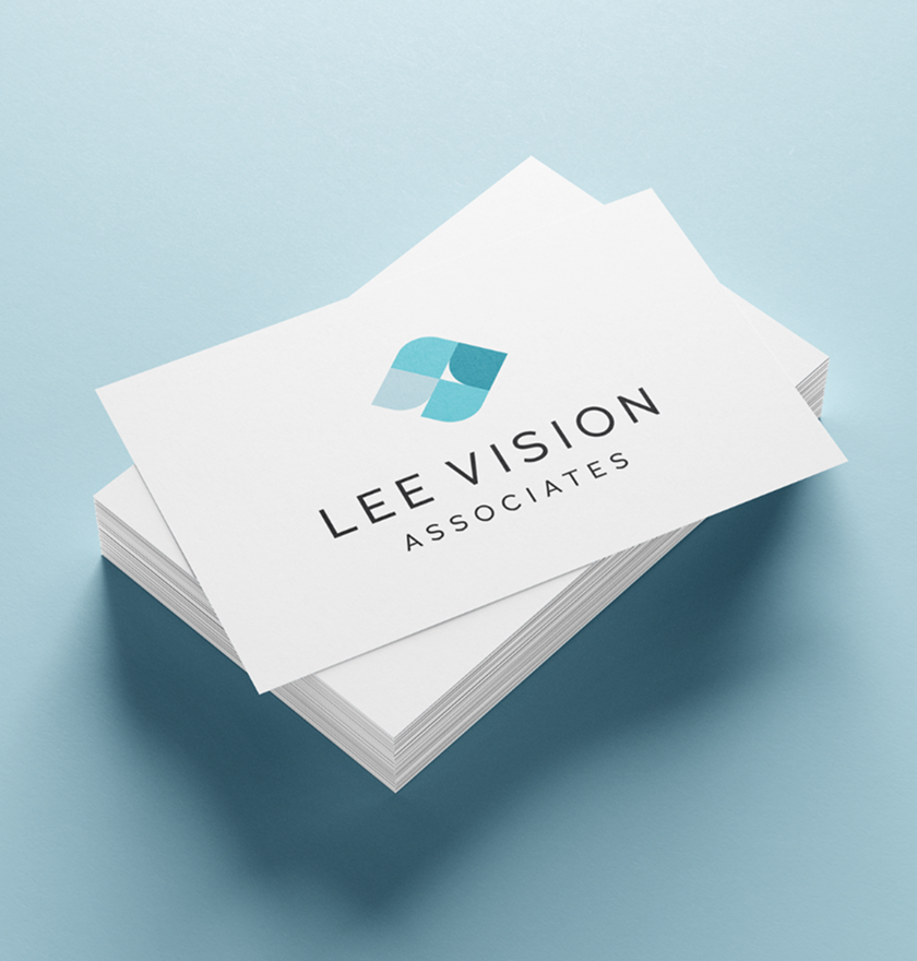 A stack of business cards with the logo and text "Lee Vision Associates" in black on a white background. The logo is abstract in shades of blue.