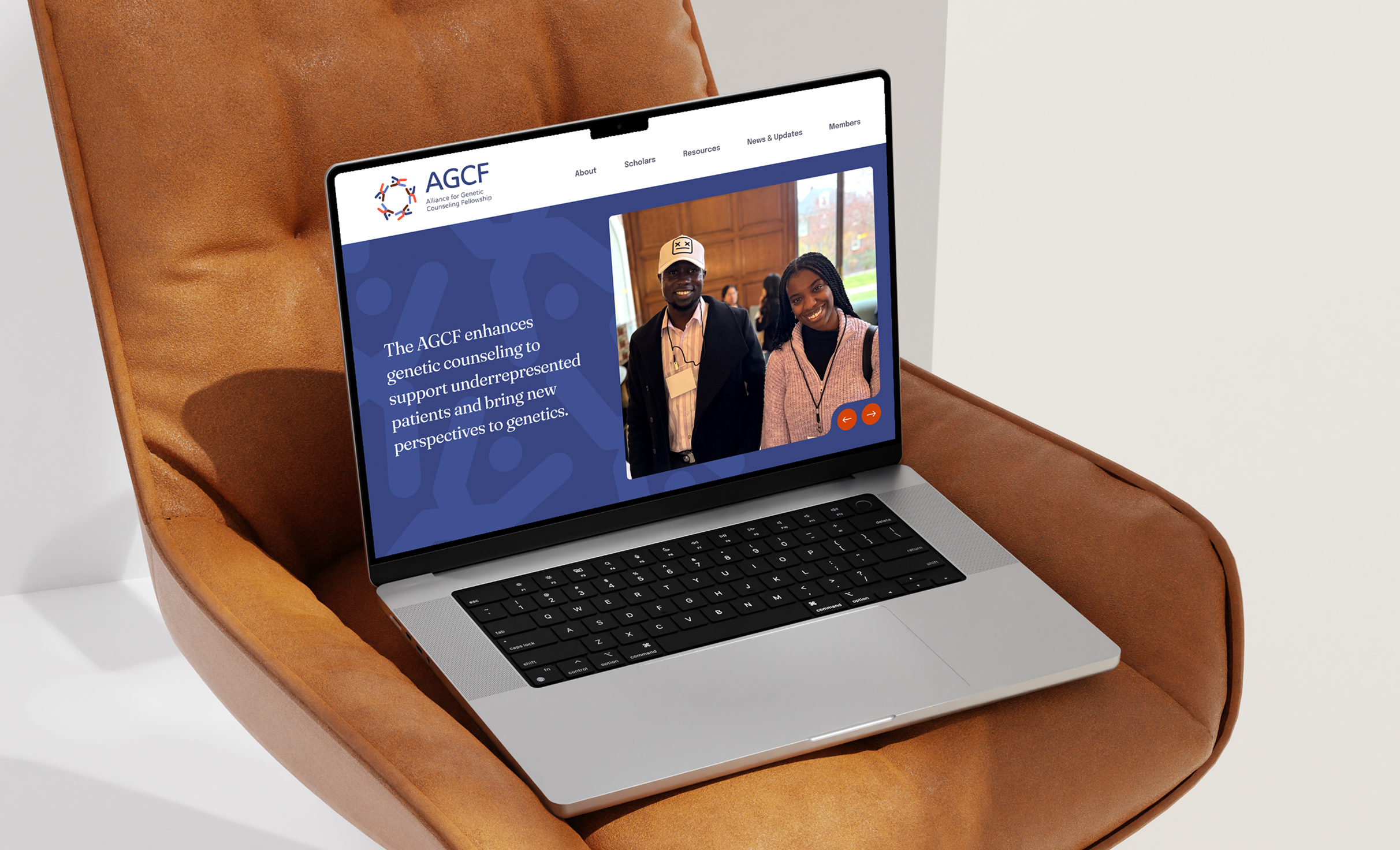 A laptop on a brown leather chair displays the AGCF website with a navy and white theme. The screen shows text about the organization and a photo of a smiling man and woman.