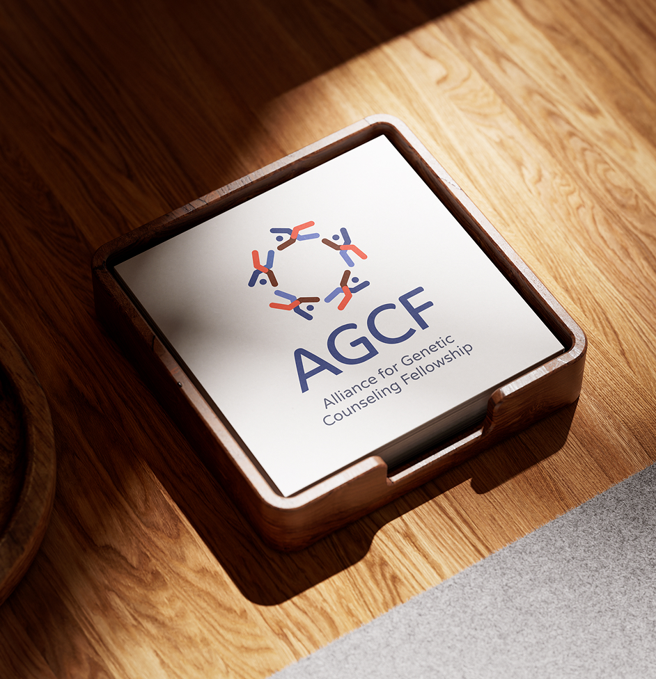 Stack of square cards on a wooden table with sunlight. Logo shows colorful abstract figures, depicting chromosomes, in a circle above "AGCF" in bold blue letters. "Alliance for Genetic Counseling Fellowship" is underneath.