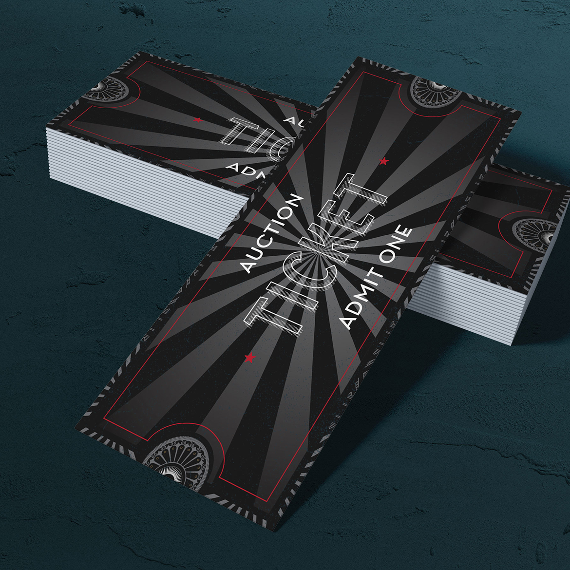 A stack of black auction tickets with a thin red border and a sunburst pattern. Bold, white text reads "Auction Ticket Admit One."
