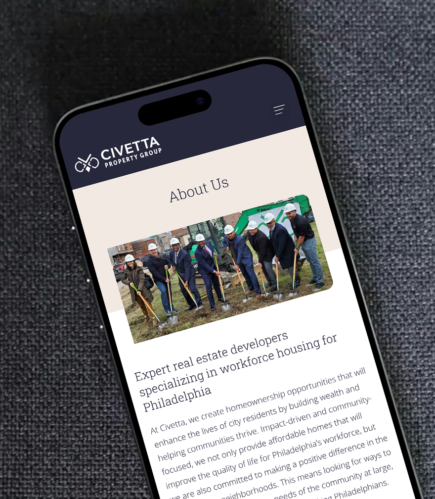 Civetta-Mobile Smartphone displaying Civetta Property Group's "About Us" page. Features a group photo of people in hard hats with shovels, indicating a groundbreaking event. Text discusses real estate development in Philadelphia.