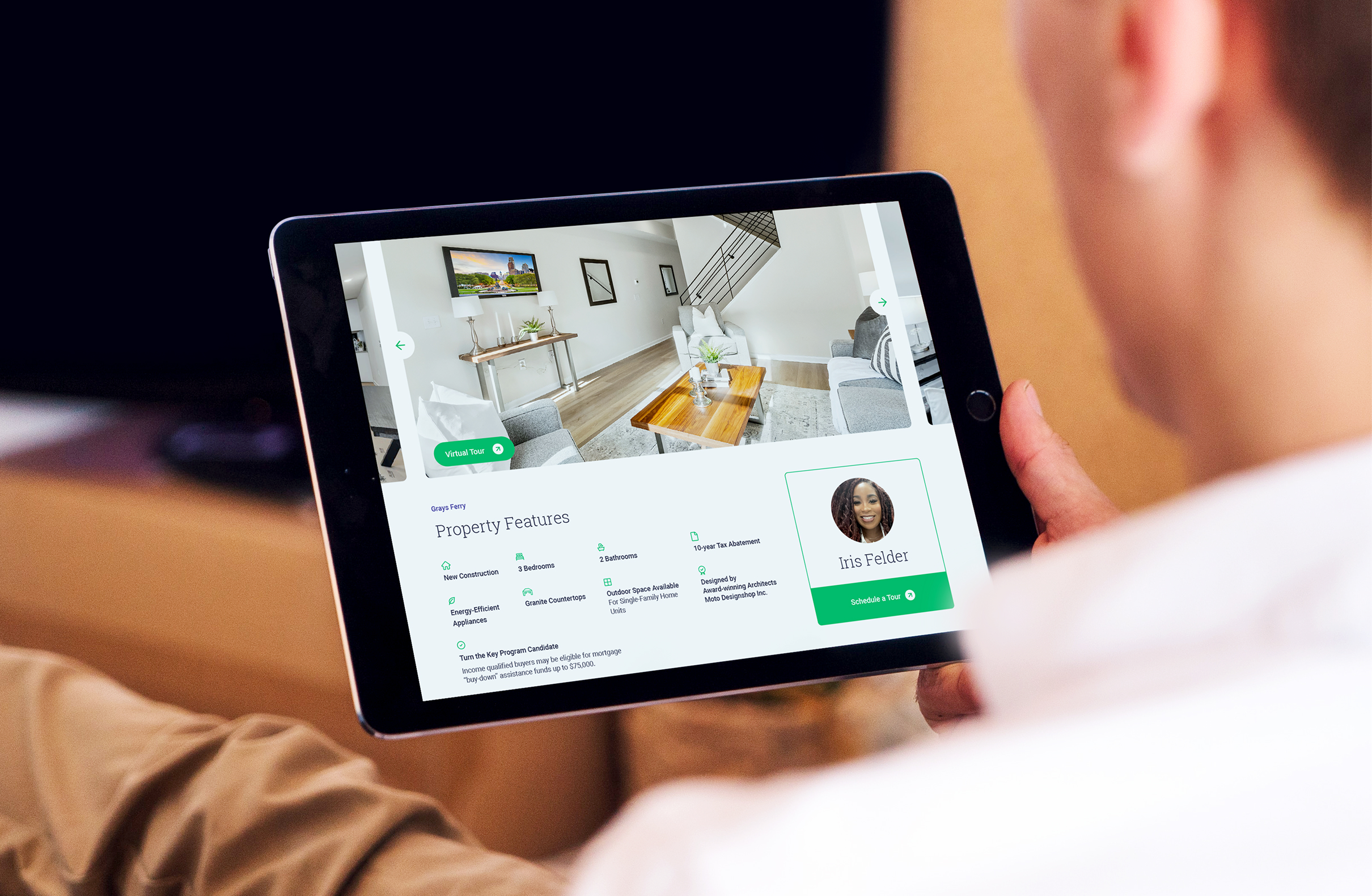 Civetta-PropertyFeatures Person holding a tablet showing property features of a listing from the Civetta Property Group website. The page features a modern living room image, property features, and agent contact info.