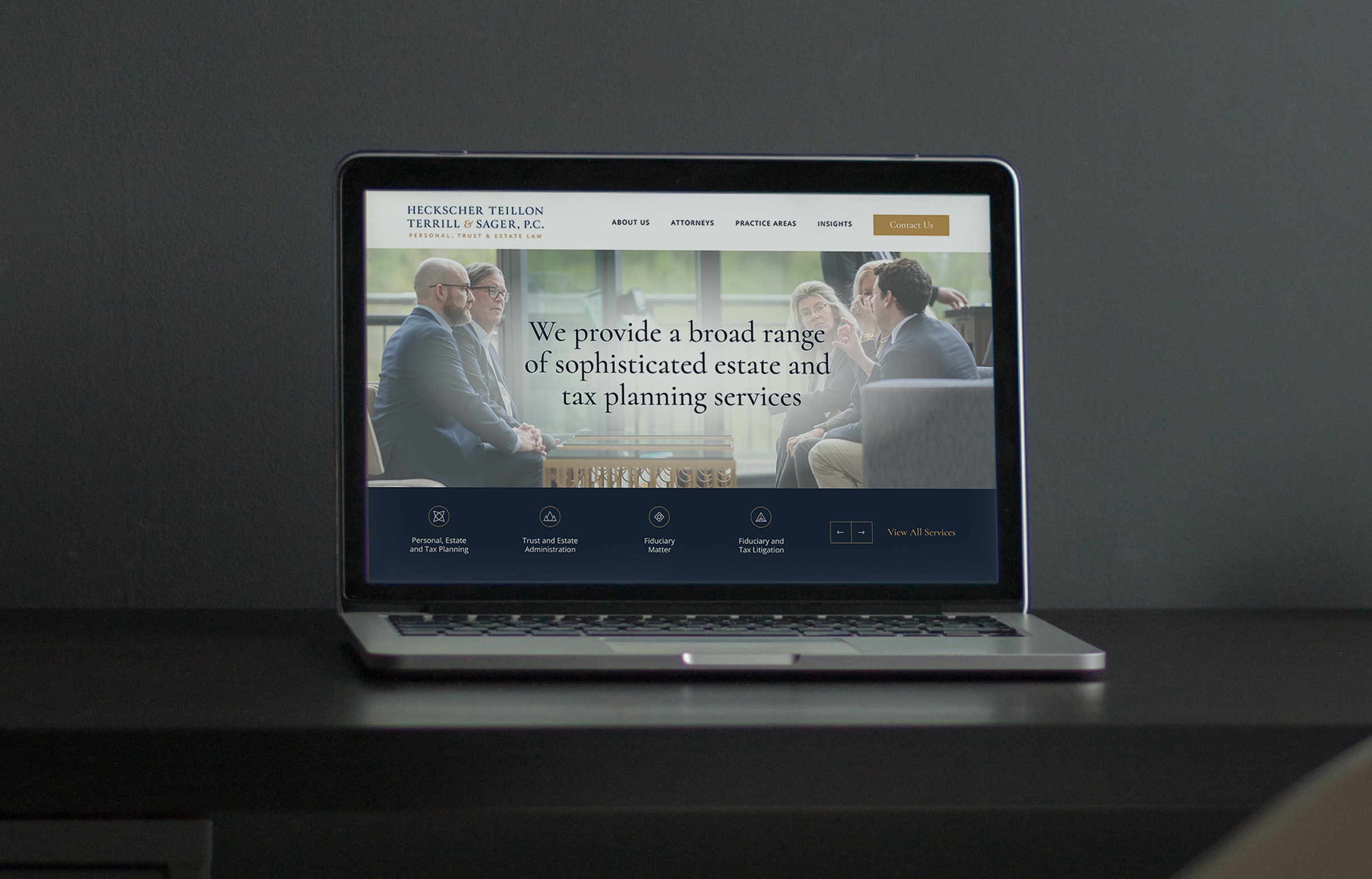 A laptop on a dark table displays the website for HTT&S. The screen shows business people in suits talking. Text overlays on top reading "We provide a broad range of sophisticated estate and tax planning services." The mood is professional.
