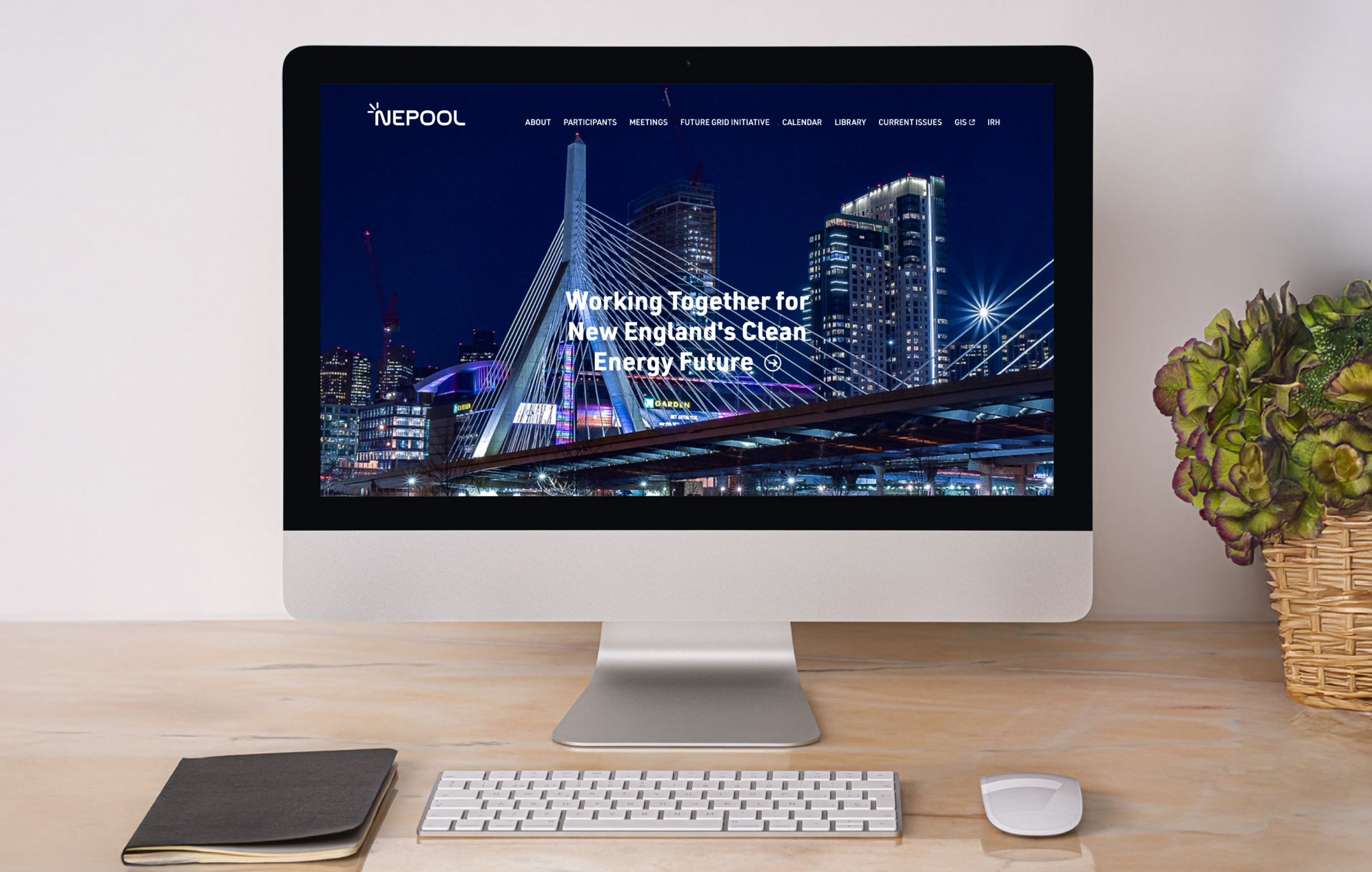 Computer screen displaying the website for NEPOOL. A cityscape with a modern bridge and illuminated skyscrapers fills the screen. Text on top of the image reads, "Working Together for New England's Clean Energy Future."