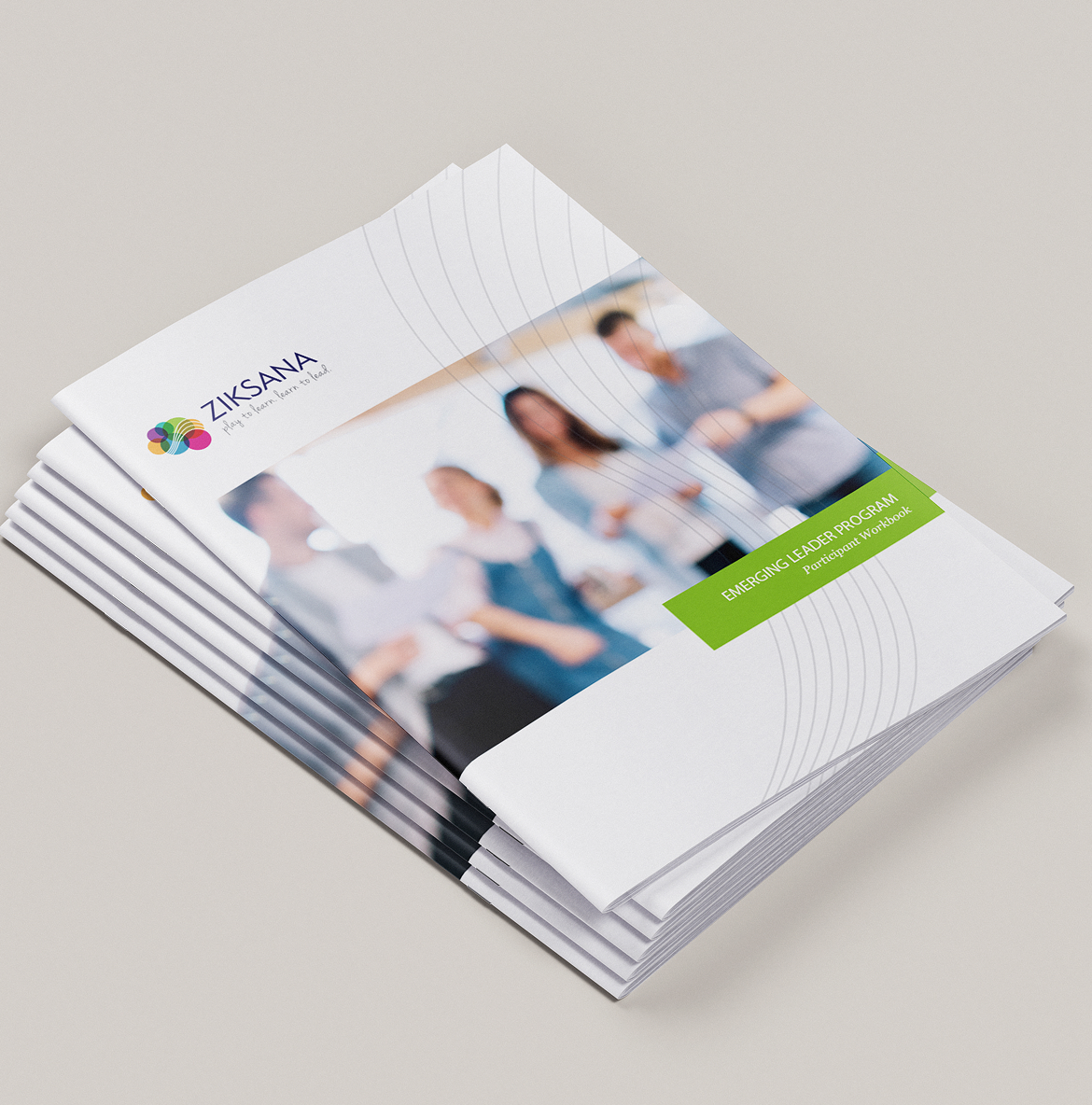 A stack of Ziksana workshop brochures titled "Emerging Leader Program" features a blurred image of four people interacting. The Ziksana logo appears at the top.
