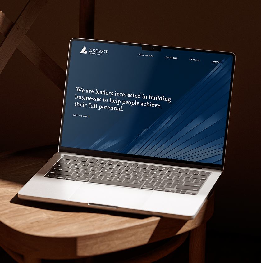 Legacy-Website Laptop displaying the homepage for Legacy Companies featuring a dark blue background with a mission statement on top in white text.